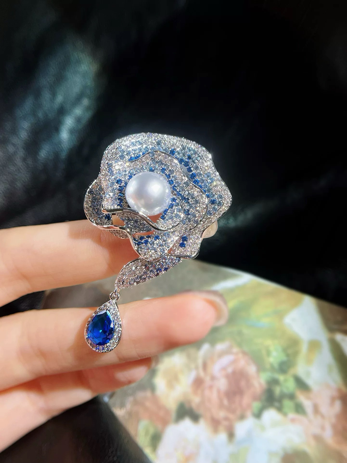 Enchanted Bloom blue rose brooch featuring an 8mm freshwater pearl and blue and clear cubic zirconia